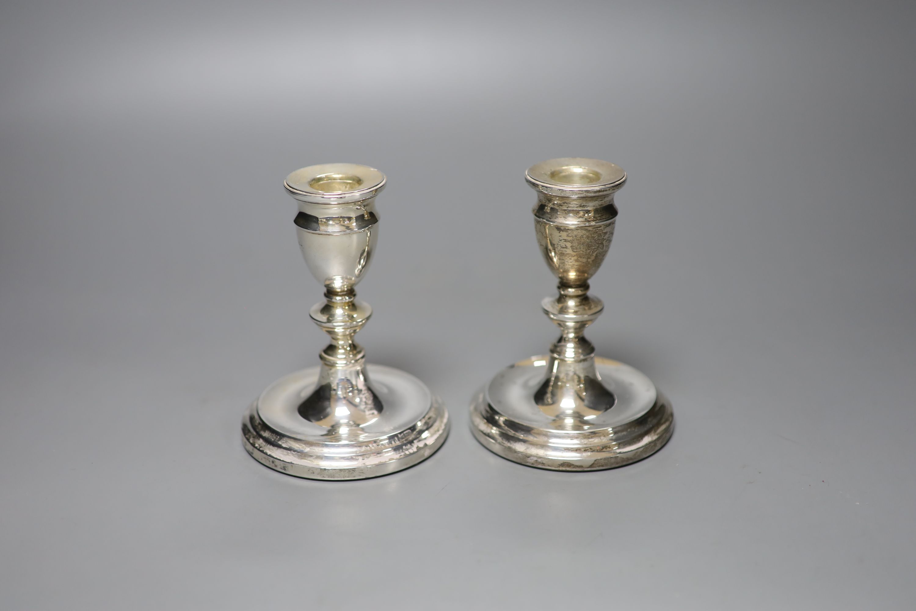 A pair of modern silver dwarf candlesticks, 12cm, a silver napkin ring and four sterling napkin rings.